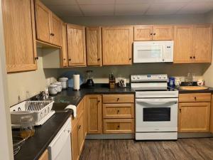 a kitchen with white appliances and wooden cabinets at Fabulous Barre Apts! in Barre