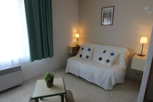 a bedroom with a white bed and a table at Sphinx Résidences - Les Doges / Le Rialto in Caen