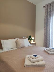 Una cama con dos toallas encima. en Kritharia Guesthouse Volos, en Kritharia