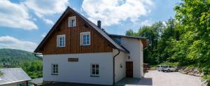 een klein wit huis met een houten dak bij Chalupa u Bedrnů in Rybniště