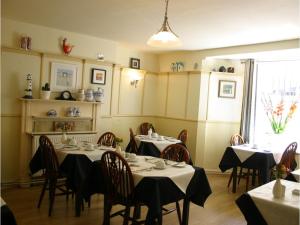 a dining room with two tables with black tablecloths at Cromwell House in Eastbourne