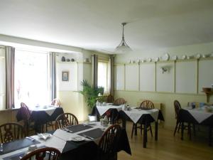 a dining room with tables with black and white tablecloths at Cromwell House in Eastbourne