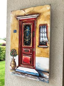 a painting of a door and a vase with a plant at Olympia by the lake in Lausanne