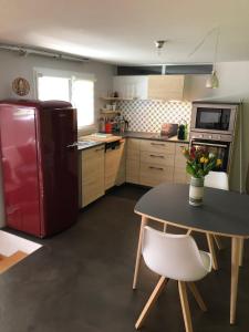 a kitchen with a red refrigerator and a table at Olympia by the lake in Lausanne