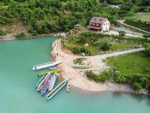 un grupo de barcos están atracados en una isla en el agua en Guest House Aprripe Guri, en Fierzë