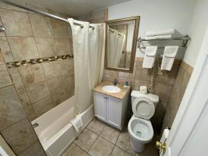 a bathroom with a toilet and a shower and a sink at Royal Inn in Claremont