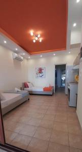 salon z 2 łóżkami i pomarańczowym sufitem w obiekcie Panorama Apt Maroulas w mieście Maroulás