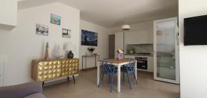 a living room with a table and a kitchen at La Dimora del Salento in Torre Lapillo