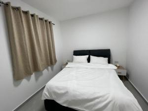 een slaapkamer met een wit bed met een zwart hoofdeinde bij בוטיק צ'יל אאוט - Boutique Chill Out in Eilat