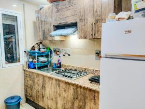 una cocina con armarios de madera y fregadero en Your new home, en Oujda