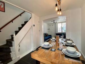 uma sala de jantar com uma mesa de madeira e uma escada em Camelford Street Cottage - Brighton em Brighton & Hove