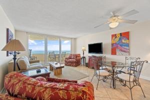 a living room with a couch and a table and chairs at Perdido Sun 610 in Perdido Key