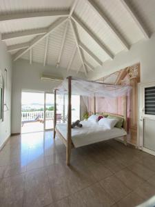 a bedroom with a canopy bed and a balcony at Grand Case Palace in Grand Case