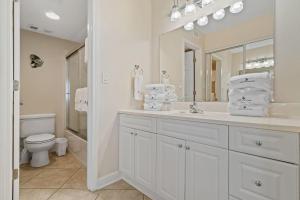 a bathroom with a sink and a toilet and a mirror at Perdido Sun 610 in Perdido Key +24 photos