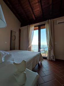 - une chambre avec un lit et une grande fenêtre dans l'établissement Agriturismo Il Casale Del Lago, à Gardone Riviera