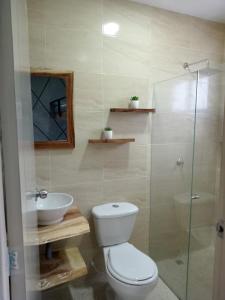 uma casa de banho com um WC, um lavatório e um chuveiro em zara's apartamento en coveñas em Coveñas