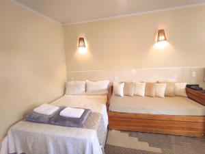 a room with two beds and two lights on the wall at Chalé com ar condicionado e garagem in Alto Paraíso de Goiás