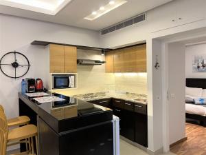 a kitchen with a black counter top and a room at Chalet at Aqualand Resort in Batroûn