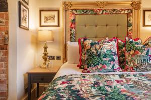 um quarto com uma cama e uma mesa com um candeeiro em The George Hotel, Amesbury, Wiltshire em Amesbury