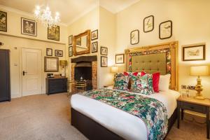 een slaapkamer met een groot bed en een open haard bij The George Hotel, Amesbury, Wiltshire in Amesbury