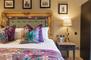 um quarto com uma cama e uma mesa com um candeeiro em The George Hotel, Amesbury, Wiltshire em Amesbury