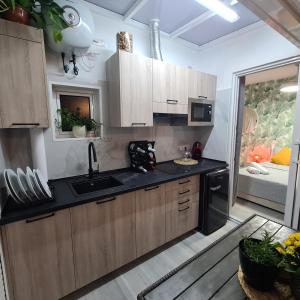 eine Küche mit Holzschränken und einer schwarzen Arbeitsplatte in der Unterkunft Apartamento Playa Chica in Las Palmas de Gran Canaria