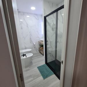 ein Bad mit einer ebenerdigen Dusche und einer Badewanne in der Unterkunft Apartamento Playa Chica in Las Palmas de Gran Canaria + 32 Fotos