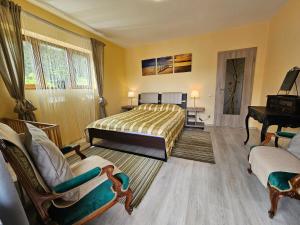 ブシュテニにあるKalinderu SKIER'S APARTAMENT BELLEVUEのベッドルーム1室(ベッド1台、椅子2脚、ピアノ付)