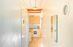una cocina con armarios de madera y un pasillo en 3 Bedroom Nice Home In Burgsvik, en Burgsvik