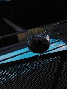 a glass of red wine sitting on a table at House Barbara in Banjole