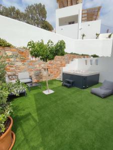 a garden with green grass and a brick wall at Harmony Luxury Villas Naxos in Naxos Chora