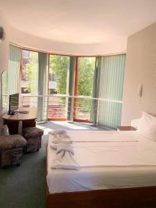 1 Schlafzimmer mit 2 Betten, einem Schreibtisch und einem Fenster in der Unterkunft Hotel Opal in Primorsko