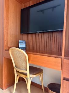 una sedia di vimini seduta davanti a una TV di Habitación privada con baño a Lima