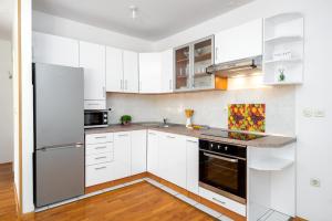 a white kitchen with white cabinets and appliances at Apartment Ana-Marija in Makarska