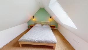 a bedroom with a bed in a attic at Charmante Maison en Pierre - Centre Ville - Plage in Ouistreham