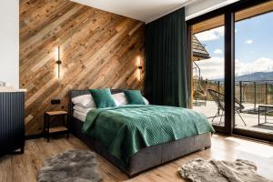 - une chambre avec un lit et un mur en bois dans l'établissement Widokowa Villa TOP - ADULTS ONLY, à Kościelisko