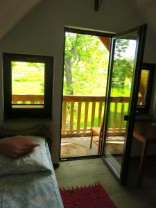 1 dormitorio con 1 cama y puerta corredera con porche en Chata Morgana, en Bolków