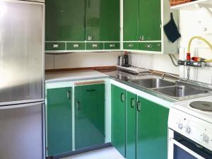 a kitchen with green cabinets and a sink at 6 person holiday home in SÖLVESBORG-By Traum in Sölvesborg