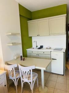 eine Küche mit einem Tisch, Stühlen und einem Waschbecken in der Unterkunft Harmony Seaside Pelion in Platanias