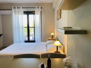 a bedroom with a white bed and a window at Harmony Seaside Pelion in Platanias