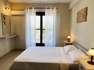 a bedroom with a large bed and a window at Harmony Seaside Pelion in Platanias