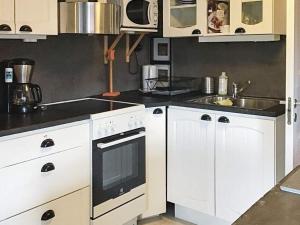 uma cozinha com armários brancos e um lavatório em Holiday home BORLÄNGE em Borlänge