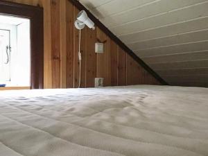 a bed in a room with wooden walls and a window at Holiday home BORLÄNGE in Borlänge