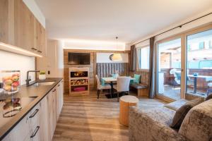 Apartment Sella في سويسي: مطبخ وغرفة معيشة مع أريكة وطاولة