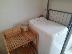 a small laundry room with a refrigerator and a shelf at La Palme de Retz in Pornic
