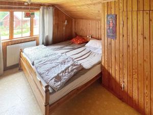Un dormitorio con una cama en una cabaña de madera. en 7 person holiday home in ÄLGARÅS-By Traum, en Skagen