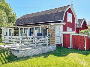 uma casa vermelha e branca com um deque em Holiday home LYSVIK em Lysvik