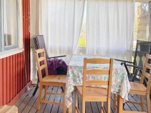 d'une salle à manger avec une table, des chaises et une fenêtre. dans l'établissement Holiday home LYSVIK, à Lysvik