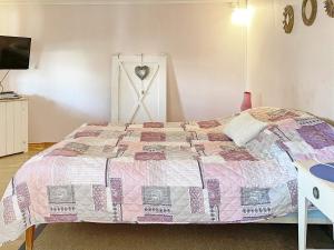 um quarto com uma cama com uma colcha em Holiday home LYSVIK em Lysvik