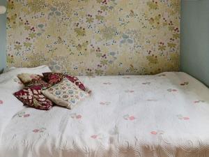 1 cama con 2 almohadas y papel pintado con motivos florales en Holiday home VARBERG XXI en Varberg